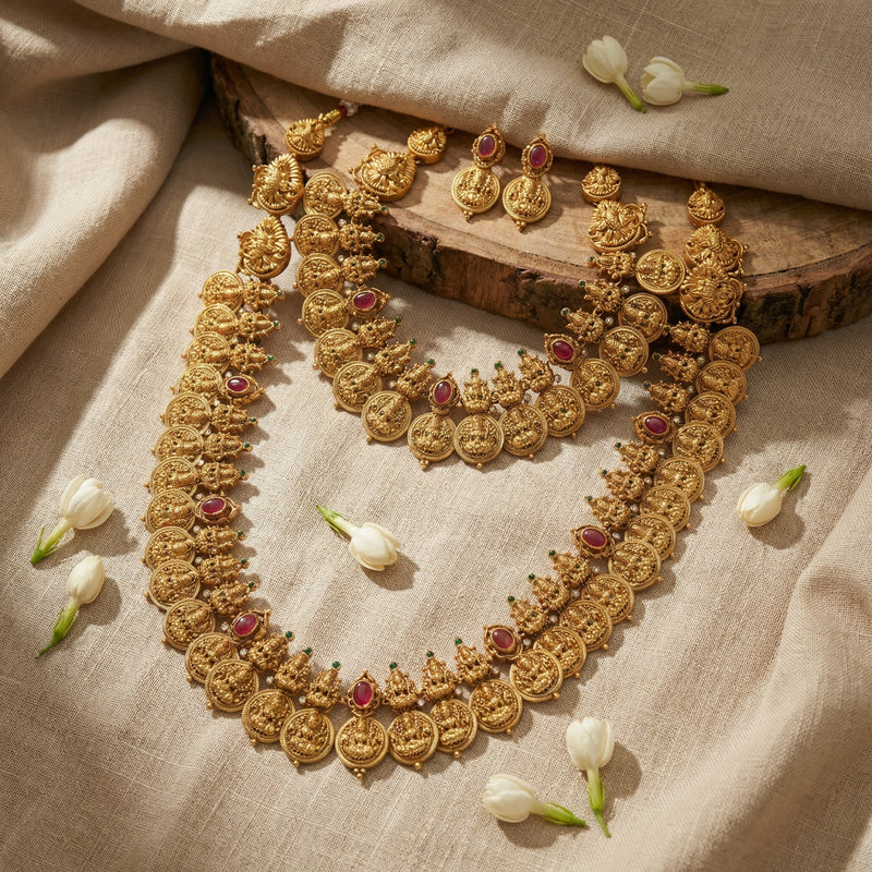 Traditional gold-toned layered jewellery with floral details on soft linen