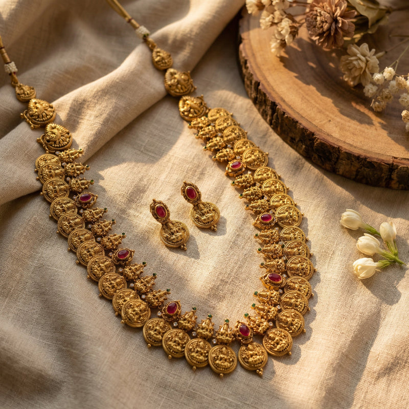 An ornate gold-toned haaram with red and green accents